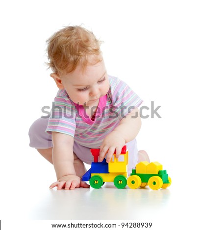 Cute little boy is playing with colorful train isolated on white