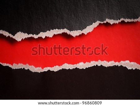 red hole with torn edges in black paper