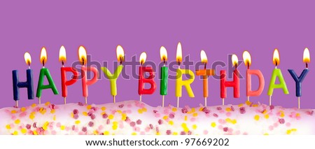 Happy birthday lit candles on purple background