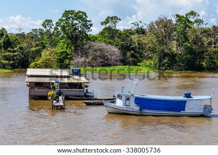 AMAZON RIVER, BRAZIL - MAY 11, 2012: Flooded house and boat as seen from the boat on the Amazon River in Brazil.
