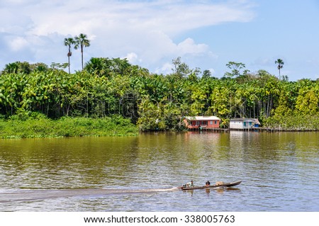 AMAZON RIVER, BRAZIL - MAY 11, 2012: Local boat and a house as seen from the boat on the Amazon River in Brazil.