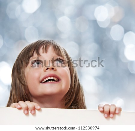 little girl with  white board with empty space - bokeh background