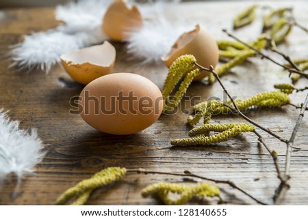 easter eggs and feathers on an old wooden table