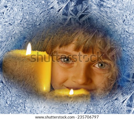 girl with candles looking through a frosted window