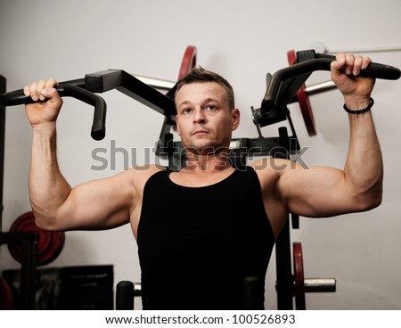 Man doing fitness training on machine with weights in a gym