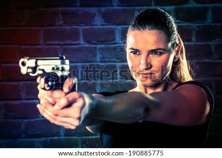 Dangerous woman terrorist dressed in black with a gun in her hands