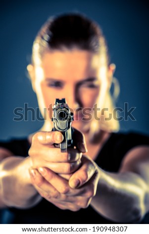 Dangerous woman terrorist dressed in black with a gun in her hands