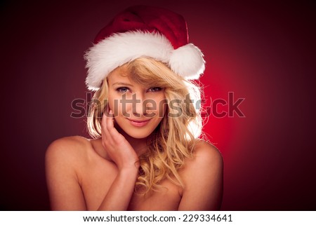 Glamorous young woman with Santa claus hat sending best  wishes for christmas