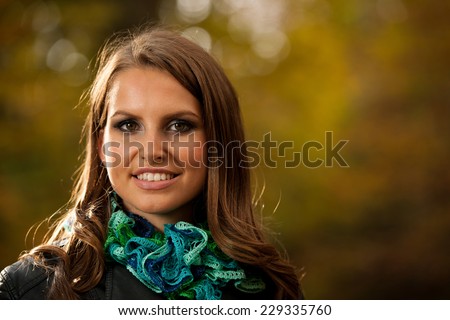 Pretty young woman on a walk in forest on late autumn day in fashionable dress