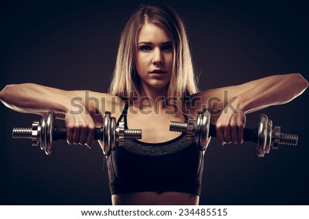 attractive young woman working out with dumbbells - bikini fitness girl with healthy lifestyle and perfect body