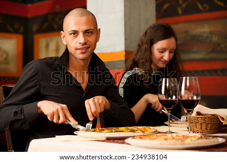 Group of people eat pizza in a restaurant