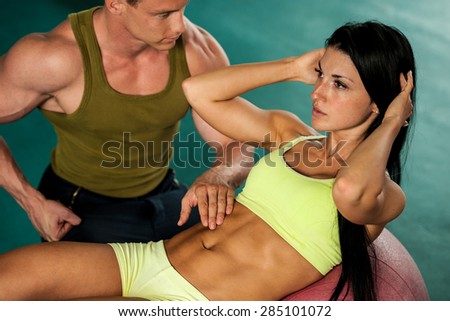 Fitness couple workout - fit mann and woman train in gym
