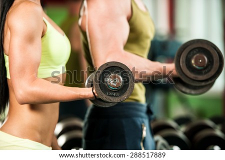 Fitness couple workout - fit mann and woman train in gym