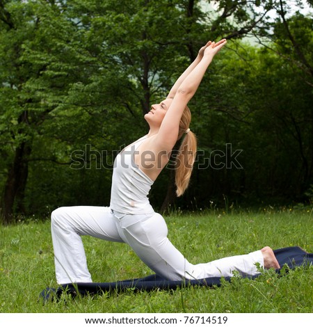 Meditation in nature - Cute young girl meditates outdoor on a green grass field in park
