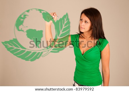 Closeup of young business woman drawing earth friendly sign  on transparent glass or foil.