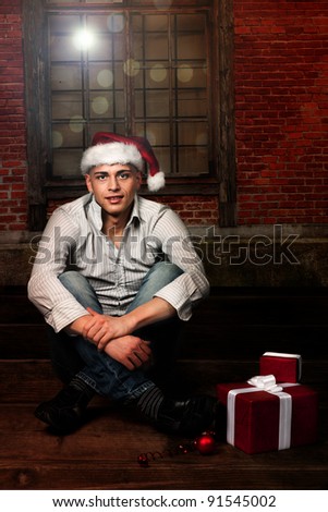 Young santa in an empty room sitting on flor