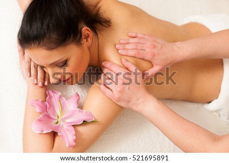 Beautiful young woman having a rejuvenating massage in a wellness studio - spa