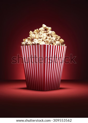 Shot of a traditional box of cinema style popcorn with spotlighting on a vibrant red background with copy space for the designer.