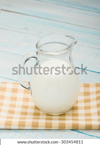 jug of fresh milk on a yellow checkered tablecloth