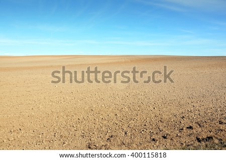 A field of plowed ground on a background of blue sky.