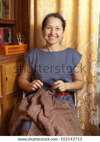 Portrait of happy and active  woman knitting with wool and metal knitting needle