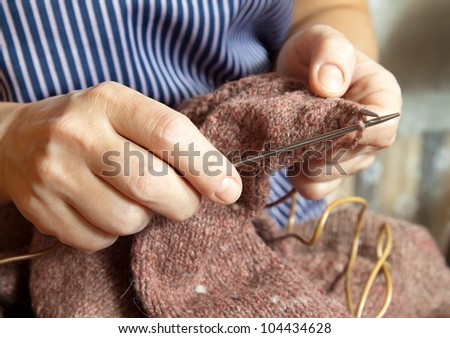 woman's hands  knitting with wool and metal knitting needle