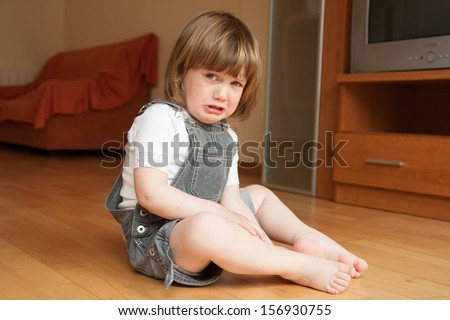 little girl sitting on the floor and crying
