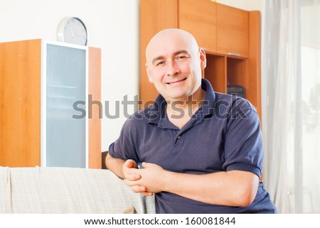Relaxed man sitting on couch in room