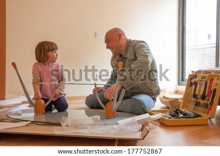 Man with child repairing furniture