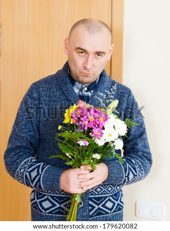 man with  bouquet of flowers near  door