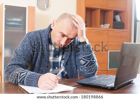 Sad man  sitting at work on laptop at home.