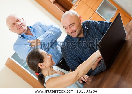 Three smiling people  at work on  laptop