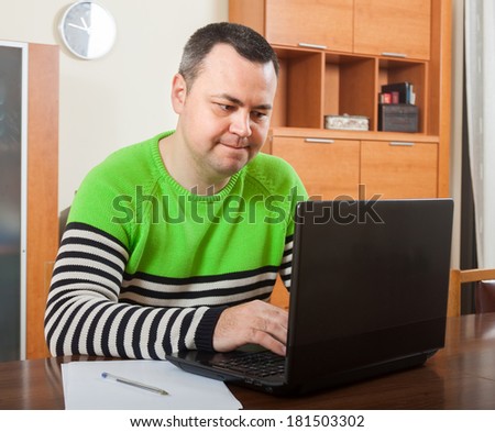 man  sitting at  computer in  home interior.