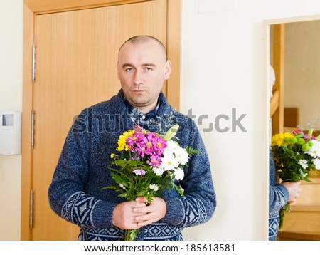 guilty man with  beautiful bouquet near  front door
