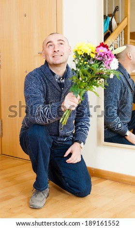 guilty man asks forgiveness with  bouquet of flowers.
