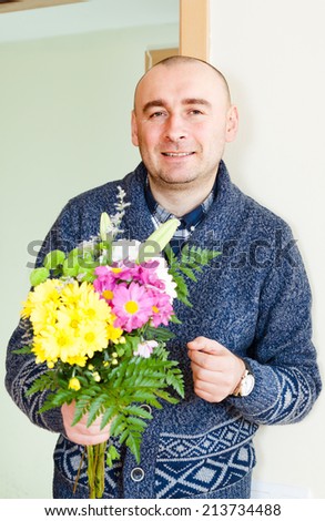 man asks forgiveness with  bouquet of flowers.