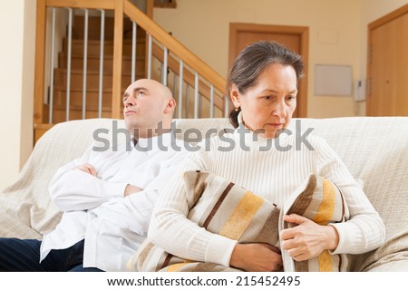 Family quarrel. Sad guy and woman during conflict in living room at home