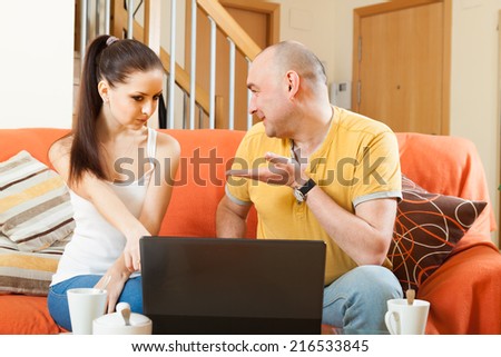 Couple of nice people at  laptop on  couch.