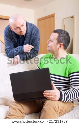 Two friends  at  computer in  home interior.