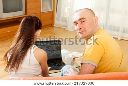 Couple of nice people at  laptop on  couch.