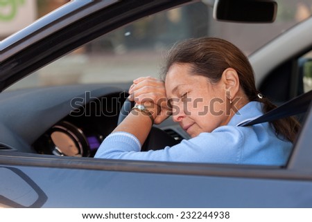 Senior woman sleeping in  black car.