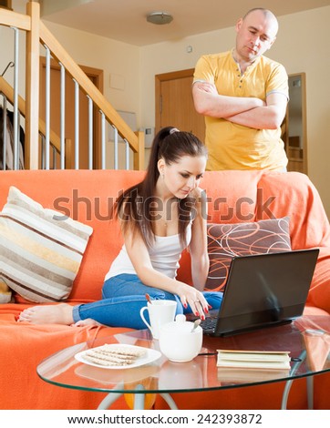 Family quarrel. Sad guy and woman with laptop during conflict