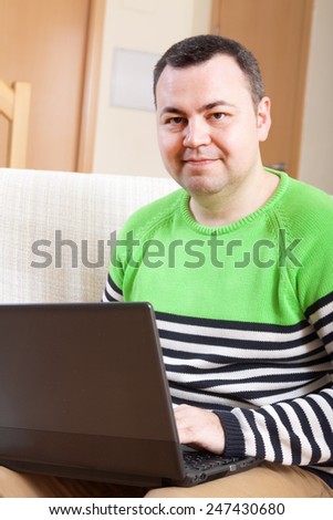 man  sitting at  computer in  home interior.