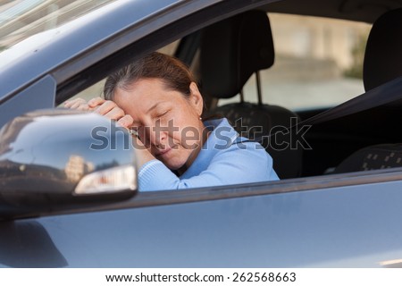 Senior woman sleeping in  black car.