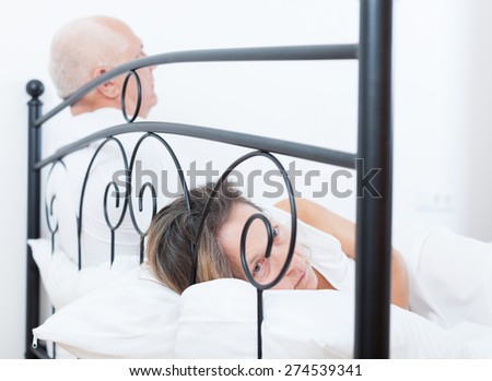 offended woman  on   bed next to   frustrated man.