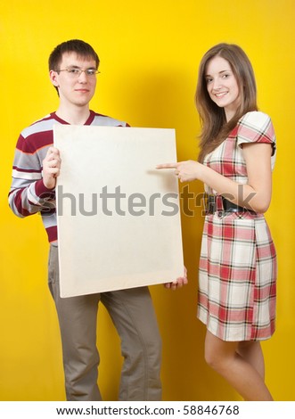 Two young people with white banner on yellow background