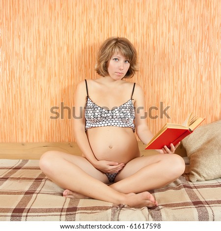 pregnant woman reading red book at home