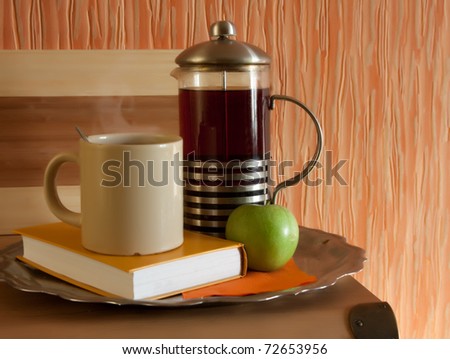 cup of tea with sweet cakes and book on table