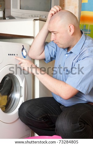 Adult  men loading the washing machine. Cleaning and Laundry