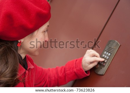 Woman pushing a door bell button